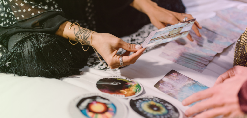 A close-up photo of a woman's hands holding astrology cards.