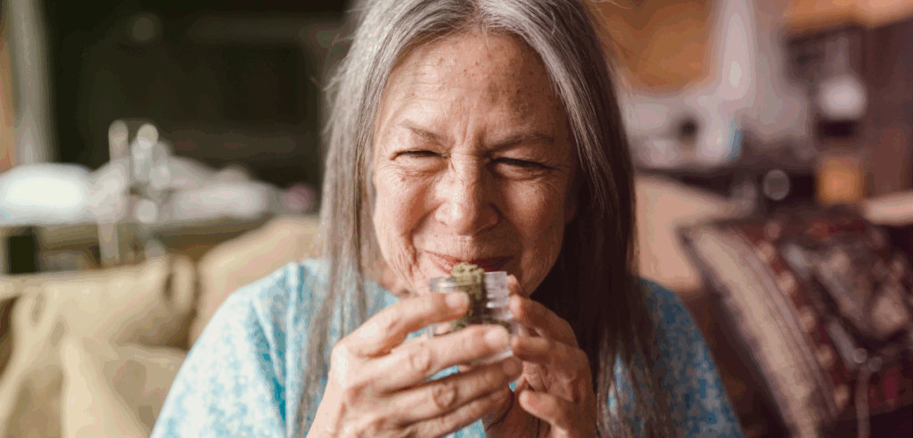 A woman smells a jar of cannabis.